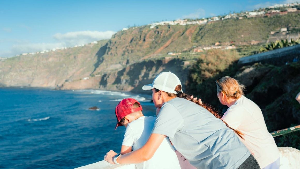 Mother and children enjoy a scenic ocean view in Puerto de la Cruz, Spain on a sunny day.